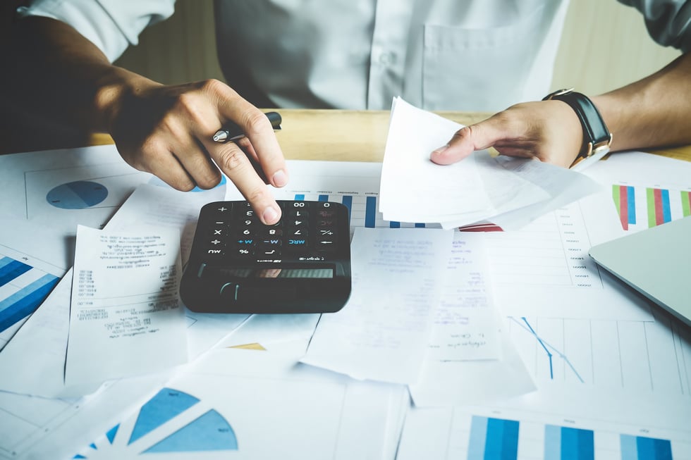 View of a Man Using a Calculator to Calculate Bills